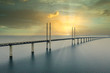 The Oresund bridge between Copenhagen Denmark and Malmo Sweden during sunset over the sea.