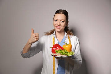 Wall Mural - Nutritionist with healthy products on light grey background