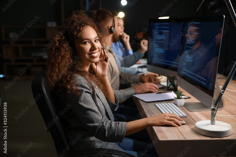 Technical support agents working in office at night