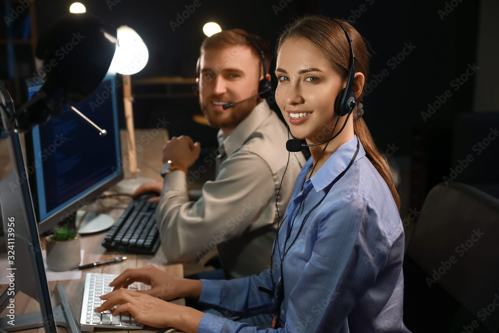 Technical support agents working in office at night