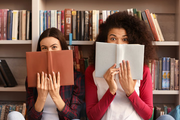 Wall Mural - Female students with books preparing for exam in library