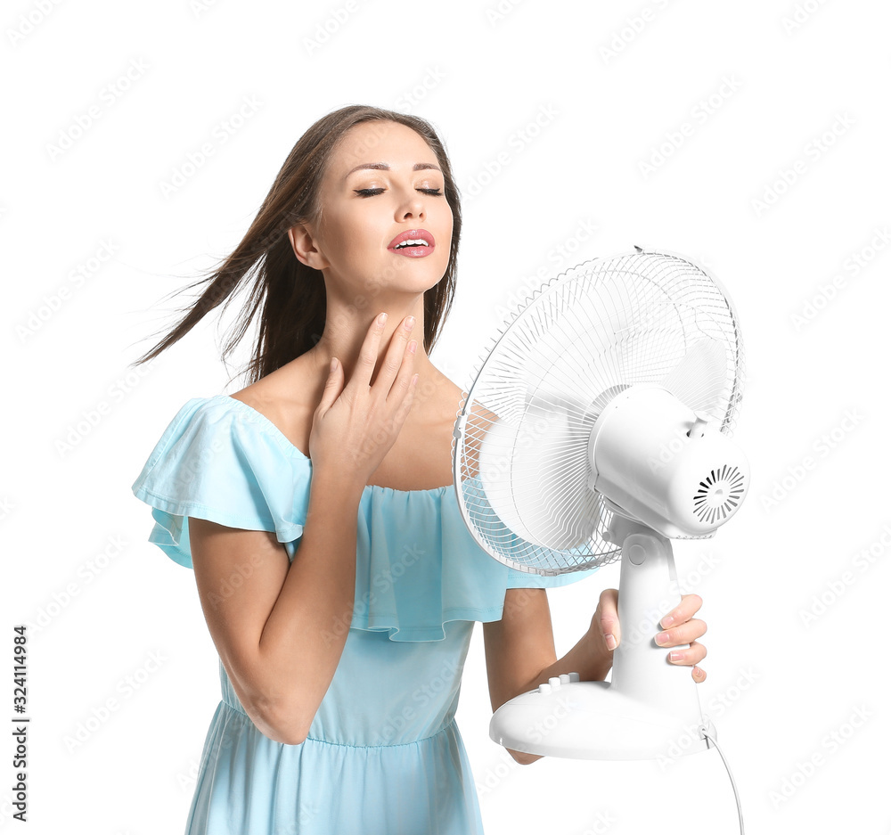 Young woman with electric fan on white background