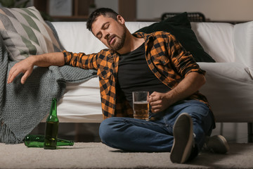 Wall Mural - Mature man drinking beer at home. Concept of alcoholism