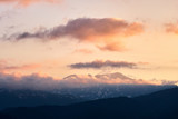 Fototapeta Góry - mountain peaks at sunset in the clouds