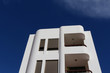 © Ines Porada - Contemporary white apartment building with art deco architectural style elements against blue sky