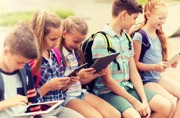 Wall Mural - primary education, friendship, childhood, technology and people concept - group of happy elementary 