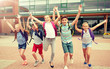 © Syda Productions - primary education, friendship, childhood and people concept - group of happy elementary school students with backpacks running and waving hands outdoors