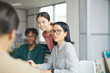 © AnnaStills - Group of young business people sitting at the table and listening to their partner during meeting at office