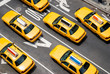 View from above of fleet of yellow taxi cabs driving down the street of Broadway in New York City