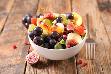 Wall Mural - bowl of fruit salad- mixed fruit salad with grape, banana, peach, and fig