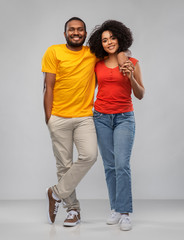 relationships and people concept - happy african american couple hugging over grey background