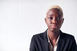© Monkey Business - Portrait Of Determined Young Businesswoman Wearing Suit Standing Against White Studio Wall