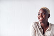 © Monkey Business - Smiling Young Businesswoman Standing Against White Studio Wall