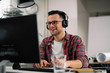 © JustLife - Businessman on video call. Handsome man in office with headphones.