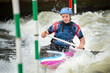 Close up of a happy GB Canoe Slalom Athlete negotiating the poles of slalom gates on white water in the C1W class