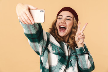 Sticker - Photo of woman taking selfie on cellphone and gesturing peace sign