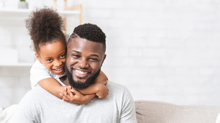 Positive portrait of afro father and daughter bonding at home