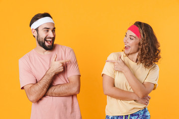 Canvas Print - Portrait of athletic couple smiling and pointing fingers at each other