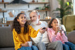 © zinkevych - Two dark-skinned girls and their granddad watching tv together