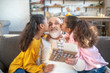 © zinkevych - Two dark-skinned sisters kissing their grandad and giving hime a present