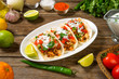 Chicken tacos with vegetables traditional Mexican dish on a wooden rustic table with ingredients. Selected focus
