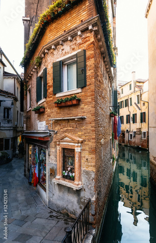 Fotomural View of the thin colorful house between canal and street in Venice, Italy