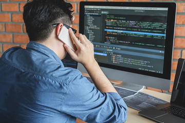 Leinwandbilder - Young Professional programmer working at developing programming and website working in a software develop company office, writing codes and typing data code, Programming with HTML, PHP and javascript