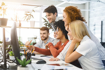 Poster - Cheerful young team looking at laptop screen together