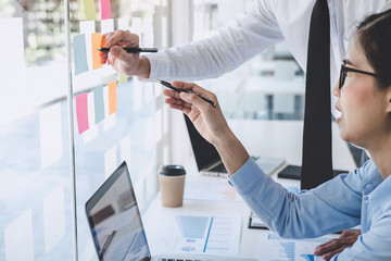 Leinwandbilder - Teamwork of business team consulting market growth on financial document graph report statistics, using post it notes in glass wall to writing strategy business plan to development grow to success