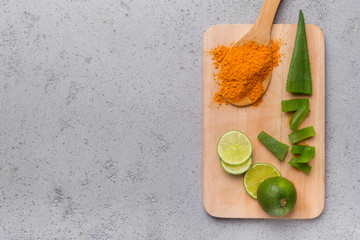 Wall Mural - A powder of turmeric, sliced Aloe vera and lime on a wood