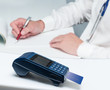 Payment of medical care. The doctor prescribes treatment. Modern payment blue terminal and card.
