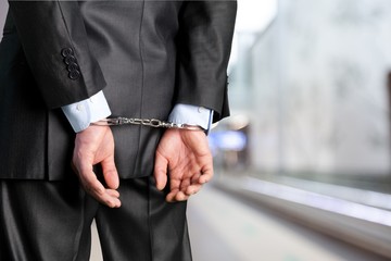 Male hands in handcuffs behind his back