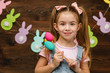 © producer - happy little child girl holding painted Easter eggs. Easter day