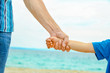 © Kostia - beautiful hands of a happy parent and child by the sea in nature