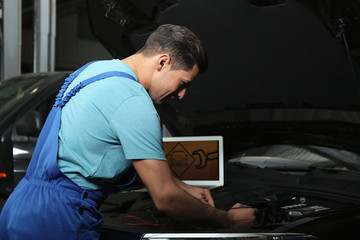 Sticker - Mechanic with laptop doing car diagnostic at automobile repair shop