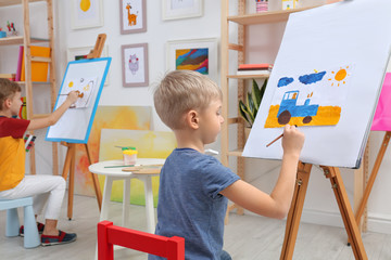 Sticker - Cute little child painting during lesson in room