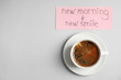 © New Africa - Delicious coffee and card with text NEW MORNING NEW SMILE on light grey background, flat lay. Space for text