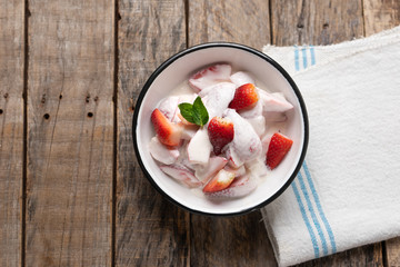 Wall Mural - Strawberries and cream dessert on wooden background