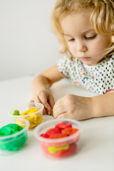 Wall Mural - the child is engaged in modeling on the table