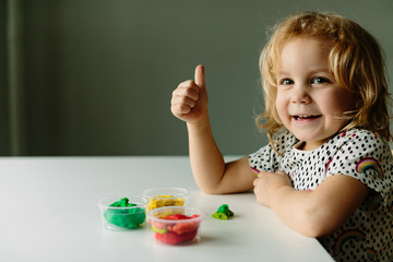 Wall Mural - the child is engaged in modeling on the table