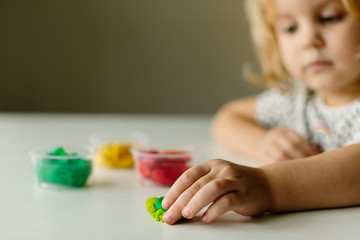 Wall Mural - the child is engaged in modeling on the table