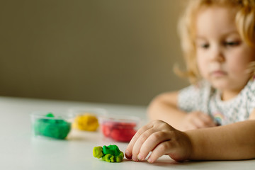 Wall Mural - the child is engaged in modeling on the table