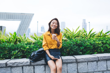 Wall Mural - Friendly Asian woman drinking coffee on street