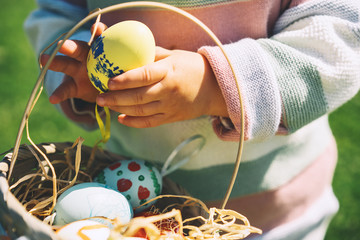 Colorful Easter eggs in basket. Kids hunt for eggs outdoors.