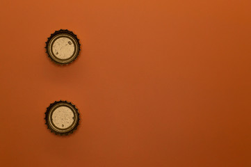 template of two bottle caps on orange background back