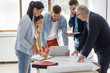 © BalanceFormCreative - Architecture professor examining blueprint with group of his students.