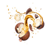 Crushed Macadamia Nuts With Splashes Of Oil In The Air, Isolated On White Background