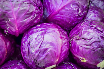 Stacked of organic red cabbage heads close-up at farmer market in Washington, USA