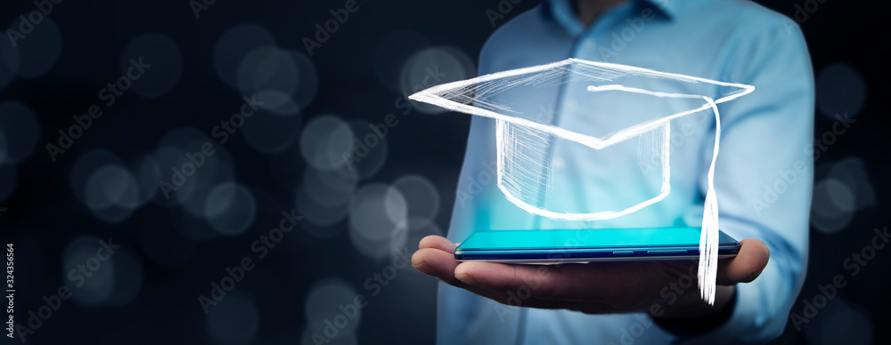 Man holding tablet with graduation cap on bokeh background - obrazy, fototapety, plakaty 
