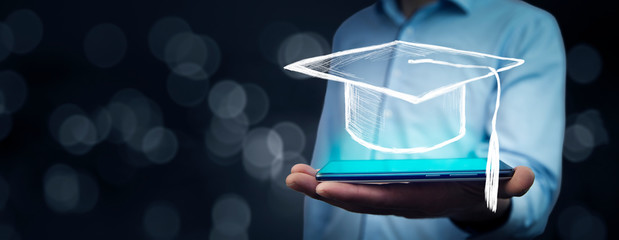 Man holding tablet with graduation cap on bokeh background